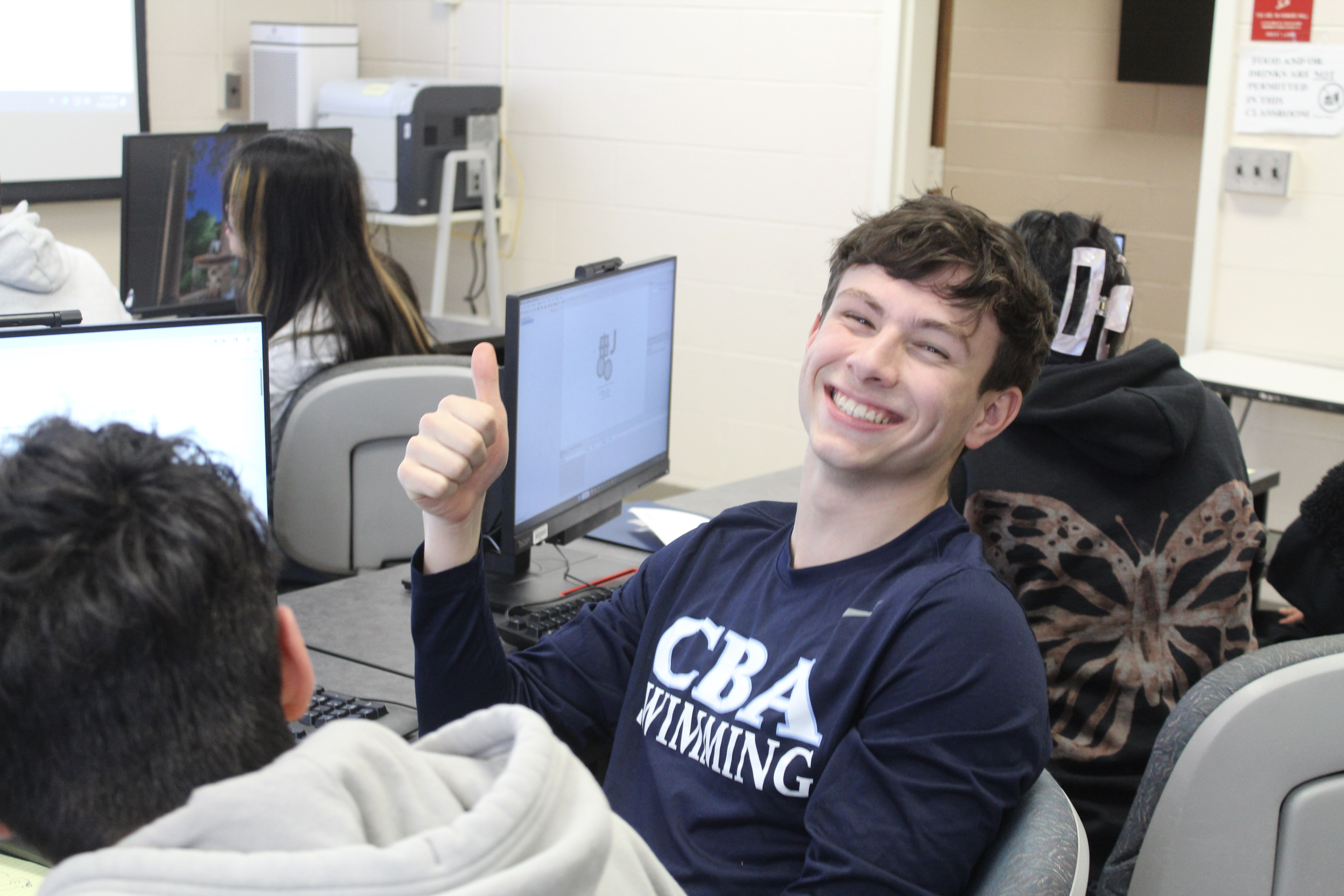 Student in computer lab giving thumbs up